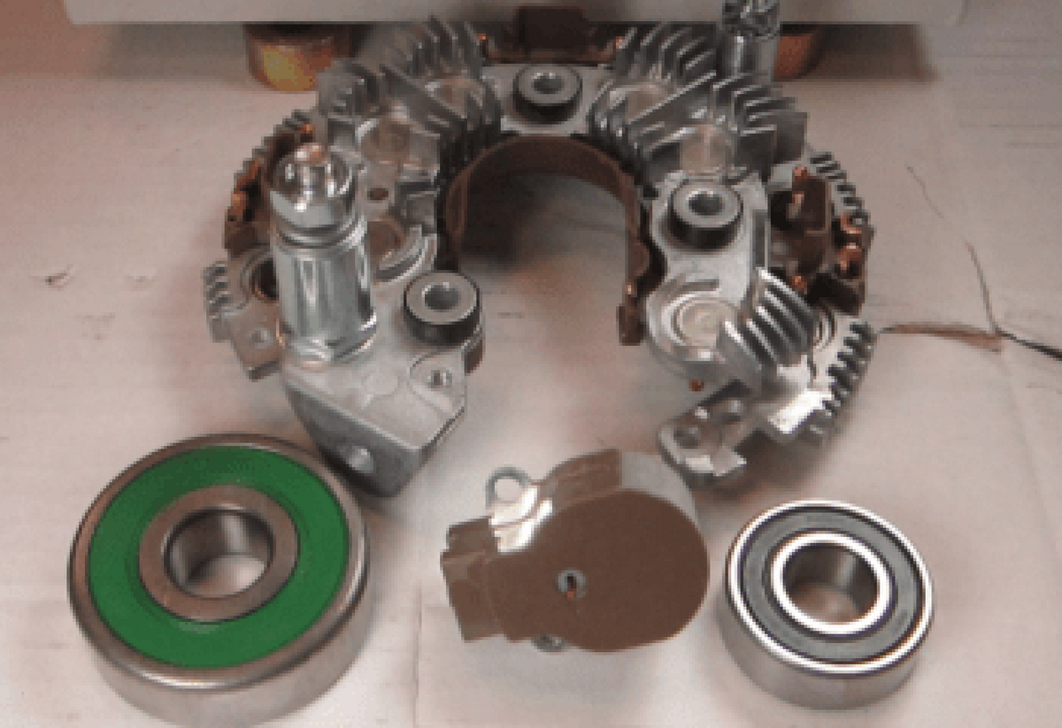 Offshore repair kit for AT series 200A 12V, 70-AT-200, rectifier assembly, bearings and a brush holder on a grey surface
