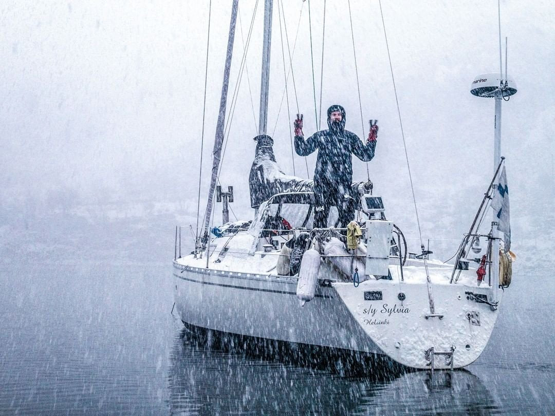 Sailing yacht in heavy snowfall with crew on deck and stern mast, lifestyle image for Scanstrut SC100 strut kit 19309