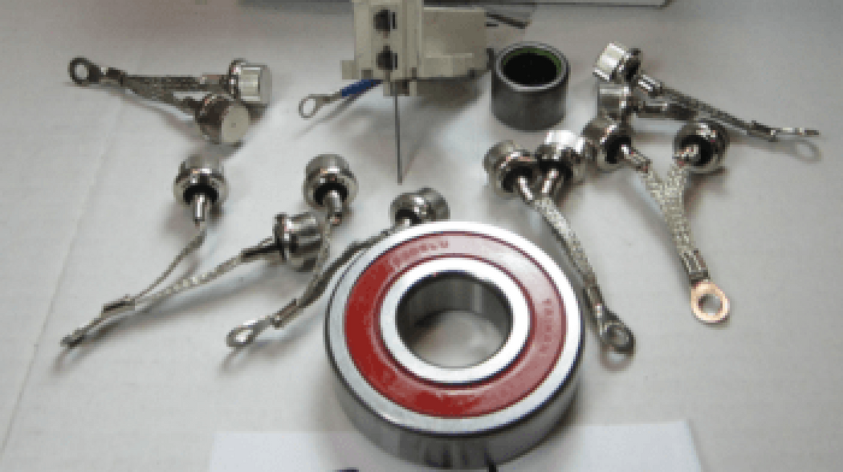 Offshore repair kit for 94 series 12/24V, 7094, bearings, brushes, rectifier diodes and leads laid out on a grey surface