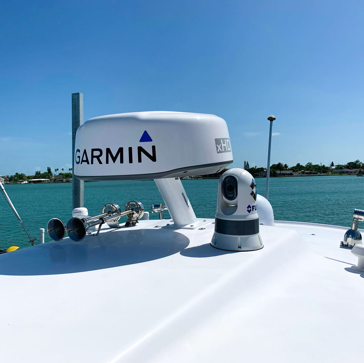 Garmin radome on a Scanstrut APT-F-250-01 forward-leaning PowerTower on a white cabin top beside a camera