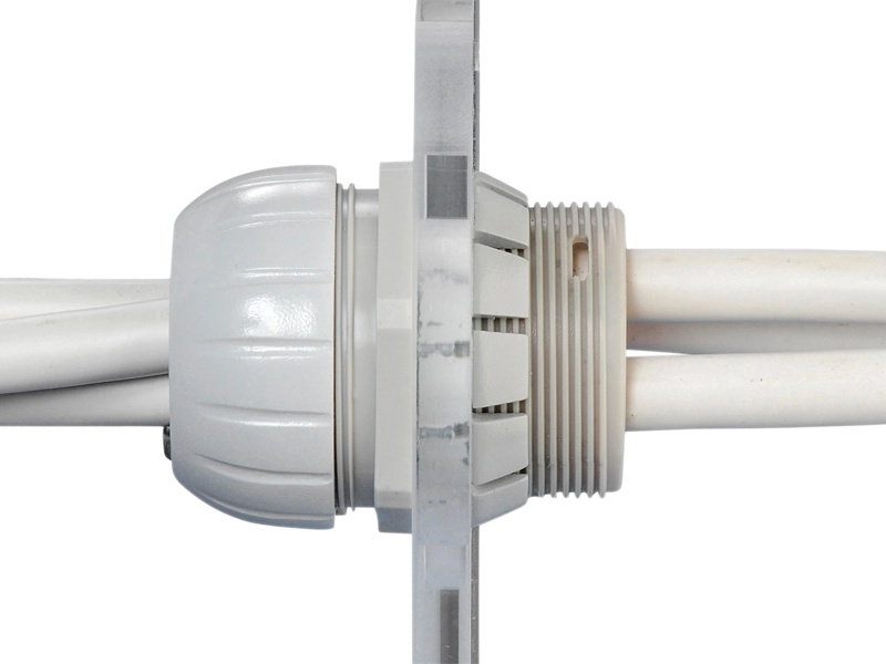 Scanstrut TBH-10 through-bulkhead cable seal close-up, grey gland fitted in a bulkhead with two cables passing through